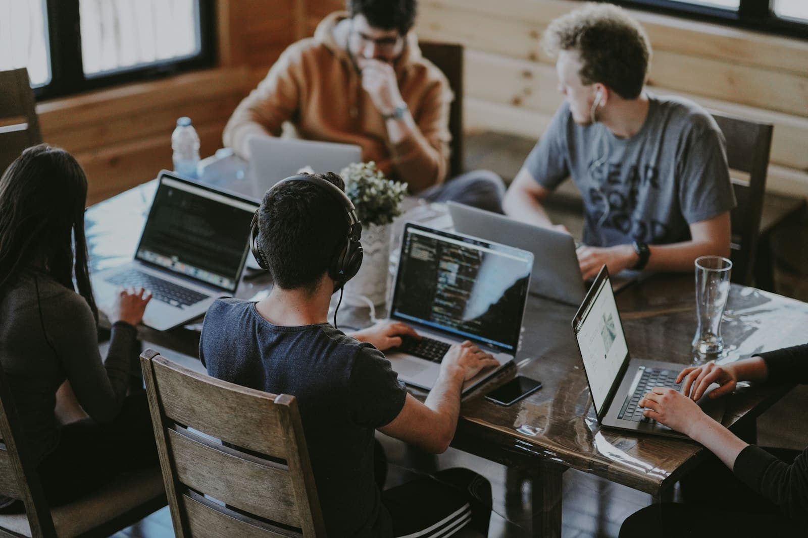 Engineers working side by side on laptops around a shared table